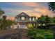 A stunning two-story home at dusk features a manicured lawn, brick driveway, and three-car garage at 4117 W Platt St, Tampa, FL 33609