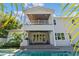 A luxurious two-story home boasts a spacious outdoor living area with access to a pool and lush landscaping at 4117 W Platt St, Tampa, FL 33609