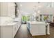 Elegant kitchen boasting a large island, marble countertops, stainless steel appliances, and hardwood floors at 4117 W Platt St, Tampa, FL 33609
