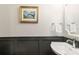 Charming powder room featuring a pedestal sink, wainscoting, and stylish fixtures at 4117 W Platt St, Tampa, FL 33609