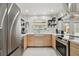 Modern kitchen featuring stainless steel appliances, light wood cabinets, quartz countertops, and a farmhouse sink at 4126 Harrisburg Ne St, St Petersburg, FL 33703