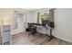 Home office space with a modern desk setup, wood-look floors, and natural light from the window at 4126 Harrisburg Ne St, St Petersburg, FL 33703