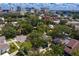 An aerial view captures a lush neighborhood street with tree-lined properties with the Tampa skyline in the background at 43 Aegean Ave, Tampa, FL 33606