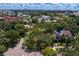 An aerial view captures a lush neighborhood street with tree-lined properties with the Tampa skyline in the background at 43 Aegean Ave, Tampa, FL 33606