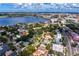 An aerial view showcases a charming neighborhood with mature trees and diverse home styles along the waterway at 43 Aegean Ave, Tampa, FL 33606