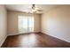 Bright bedroom featuring hardwood floors, a modern ceiling fan, and a window with vertical blinds at 4944 Cypress Trace Dr, Tampa, FL 33624