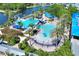 Aerial view showcasing a luxurious pool area with slide, palm trees, and nearby lake access at 5128 Admiral Pointe Dr, Apollo Beach, FL 33572