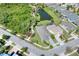 An aerial view shows the beautiful home's setting with lush greenery, pond views, and neighborhood charm at 5128 Admiral Pointe Dr, Apollo Beach, FL 33572