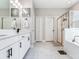 Bathroom featuring double vanity sinks, a glass shower, and a soaking tub at 5128 Admiral Pointe Dr, Apollo Beach, FL 33572