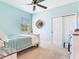 Bright bedroom features cool blue walls, a ceiling fan, and a cozy single bed with a blue coverlet at 5128 Admiral Pointe Dr, Apollo Beach, FL 33572