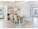 Traditional dining room features wood-look tile floors, a chandelier, and view to front door at 5128 Admiral Pointe Dr, Apollo Beach, FL 33572
