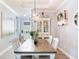 Dining room features a chandelier, decorative shelving, and a long wooden table with white chairs at 5128 Admiral Pointe Dr, Apollo Beach, FL 33572