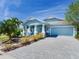 Beautiful blue single-story home with a brick driveway, well-maintained lawn, and an inviting front porch at 5128 Admiral Pointe Dr, Apollo Beach, FL 33572