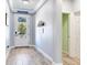 Bright hallway with wood-look tile flooring, white trim, and light gray walls that create a clean aesthetic at 5128 Admiral Pointe Dr, Apollo Beach, FL 33572