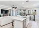 Bright kitchen with white island and dark bar table, open to living area with TV at 5128 Admiral Pointe Dr, Apollo Beach, FL 33572