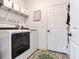 Laundry room with a washer and dryer, storage shelves, and a door leading outside at 5128 Admiral Pointe Dr, Apollo Beach, FL 33572