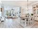Open concept living and dining area featuring wood tile floors, a large couch, and a dining table with seating at 5128 Admiral Pointe Dr, Apollo Beach, FL 33572