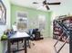 Well-lit home office with large windows, a functional desk setup, and ample storage with a full bookcase at 5128 Admiral Pointe Dr, Apollo Beach, FL 33572