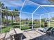 Enjoy the screened-in patio featuring a hammock, outdoor furniture, and tranquil pond views in a backyard setting at 5128 Admiral Pointe Dr, Apollo Beach, FL 33572
