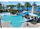 Resort-style pool area featuring a lighthouse-themed slide, lounge chairs, and lush tropical landscaping at 5128 Admiral Pointe Dr, Apollo Beach, FL 33572