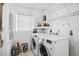 Laundry room with new front load washer and dryer and overhead shelving at 5758 20Th N Ave, St Petersburg, FL 33710