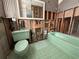 Classic bathroom with a vintage green tub and toilet, ready for restoration at 6305 Bahama Shores S Dr, St Petersburg, FL 33705