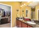 Bathroom featuring a double sink vanity with a large mirror and walk-in closet access at 689 Chipper Dr, Sun City Center, FL 33573