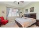 Comfortable bedroom with a ceiling fan, natural light, and a king sized bed at 689 Chipper Dr, Sun City Center, FL 33573