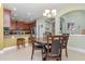 Bright dining area with a chandelier, seating for four, and an open view to the kitchen with dark wood cabinetry at 689 Chipper Dr, Sun City Center, FL 33573