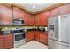 Kitchen featuring stainless steel appliances, dark wood cabinets and granite countertops at 689 Chipper Dr, Sun City Center, FL 33573