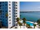 Exterior shot of apartment complex with a pool, tiki umbrellas, palm trees, and serene ocean views at 7200 Sunshine Skyway S Ln # 3D, St Petersburg, FL 33711