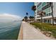 The property features a serene oceanfront walkway leading to a pool and lounge area with tiki umbrellas at 7200 Sunshine Skyway S Ln # 3D, St Petersburg, FL 33711