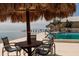 Inviting pool area featuring a tiki umbrella, table, chairs, and calming ocean views beyond at 7200 Sunshine Skyway S Ln # 3D, St Petersburg, FL 33711