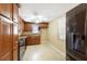 Well-lit kitchen with wood cabinets, black appliances, and tile flooring at 7315 Lincoln Park Ln, Port Richey, FL 34668