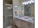 Bathroom featuring double vanity, framed mirror and glass-enclosed shower at 7392 Meadow Brook Ln, Spring Hill, FL 34606