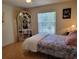 Bedroom with wooden floors, a window, and a display cabinet at 7392 Meadow Brook Ln, Spring Hill, FL 34606