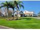 Exterior view of a clubhouse with beautiful landscaping and palm trees at 7392 Meadow Brook Ln, Spring Hill, FL 34606