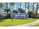 Welcome to Timber Pines sign with lush landscaping and mature trees at 7392 Meadow Brook Ln, Spring Hill, FL 34606