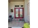 Inviting front door with glass panels and sidelights, complemented by chairs and brick accents at 7392 Meadow Brook Ln, Spring Hill, FL 34606