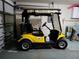 Garage interior featuring a yellow golf cart with a striped awning at 7392 Meadow Brook Ln, Spring Hill, FL 34606