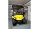 Garage showcasing a yellow Yamaha golf cart, offering convenient transportation around the community at 7392 Meadow Brook Ln, Spring Hill, FL 34606