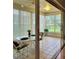 Bright sunroom featuring tile floors, vertical blinds, and a table with seating overlooking a lush yard at 7392 Meadow Brook Ln, Spring Hill, FL 34606