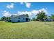 Expansive backyard featuring lush green grass and mature trees, perfect for outdoor activities and relaxation at 7509 Mesa St, North Port, FL 34287