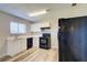 Well-lit kitchen featuring white cabinets, laminate counters, black appliances, and modern wood-look flooring at 7509 Mesa St, North Port, FL 34287