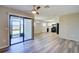 Open living room featuring modern wood-look floors, ceiling fan, and access to screened porch at 7509 Mesa St, North Port, FL 34287