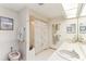 Spacious bathroom with double sinks, tile floors, and a glass enclosed shower at 8823 Crescent Forest Blvd, New Port Richey, FL 34654