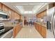 Spacious kitchen with wood cabinets and views into the dining area at 8823 Crescent Forest Blvd, New Port Richey, FL 34654