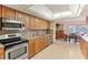 Well-lit kitchen with wood cabinets and stainless steel appliances at 8823 Crescent Forest Blvd, New Port Richey, FL 34654