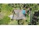 Aerial view of a home featuring a tile roof, screened pool, mature trees, and a well-manicured lawn at 9302 Deer Creek Dr, Tampa, FL 33647