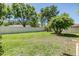 Lush backyard featuring a green lawn and mature trees and a white fence at 9302 Deer Creek Dr, Tampa, FL 33647